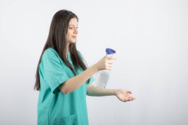 Genç uzun saçlı hemşire dezenfekte ediyor.