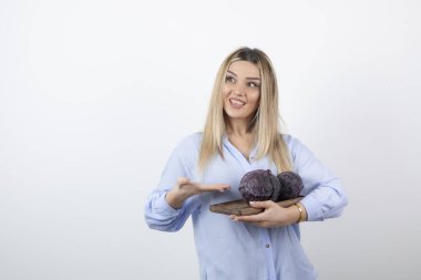 Gülümseyen güzel bir kadının resmi. Elinde lahana tutan bir model.