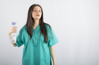 Genç hemşire covid-19 sırasında kendini dezenfekte ediyor.