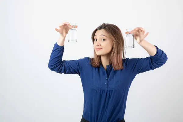 Imagem da jovem mulher em blusa azul mostrando vidro de água — Fotografia de Stock