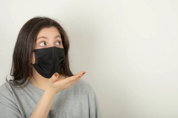 Jovem mulher usando máscara e olhando para longe — Fotografia de Stock