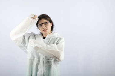 Koruyucu ceketli ve gözlüklü bir kadın kameraya bakıyor.