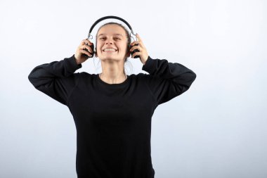 Kulaklıkla müzik dinleyen genç bir kızın fotoğrafı.