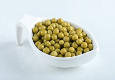 Terbiye edilmiş zeytinlerin beyaz arka plandaki beyaz kasedeki fotoğrafını kapat.