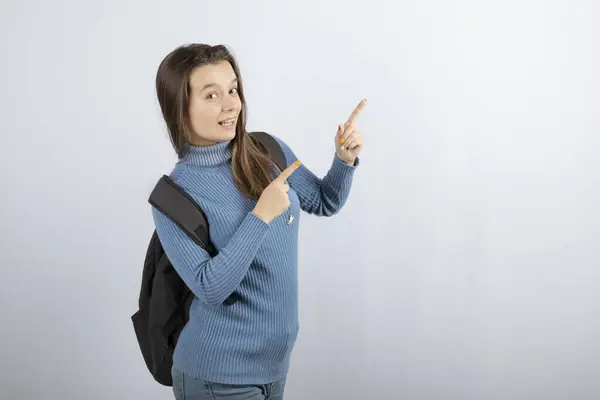 Foto de retrato de uma jovem modelo com mochila apontando para cima — Fotografia de Stock