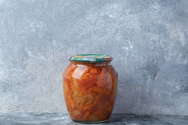 Стеклянная банка со смешанными овощами на мраморном фоне