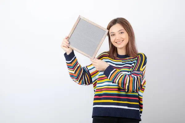 Foto de uma jovem modelo de pé e segurando uma moldura — Fotografia de Stock