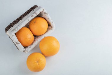 Taze portakal meyveleriyle dolu tahta bir sepet.