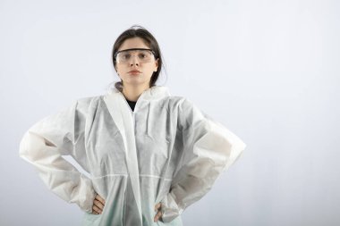 Koruyucu ceketli ve gözlüklü genç bir kadın kameraya bakıyor.