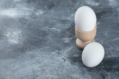 Gri arka planda iki taze organik yumurta.