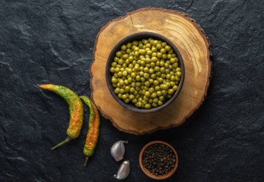 Tahta tahtada yeşil zeytinlerle dolu ahşap kaseyi kapat.