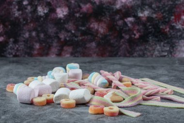 Mermer zeminde karışık şekerlemeler ve jelibonlar.