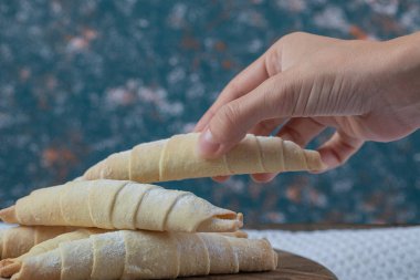 Ahşap bir tahtanın tepesinde şeker tozu olan beyaz mutaki kurabiyeler.