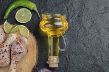 Çiğ tavuk bacakları ve bir şişe yağ.