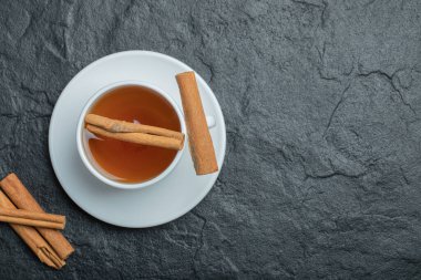 Tarçın çubukları ve aşılanmış bir fincan çay.