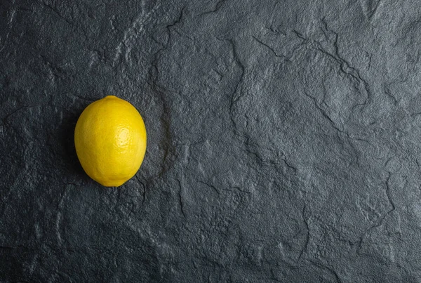 A single lemon on the black background