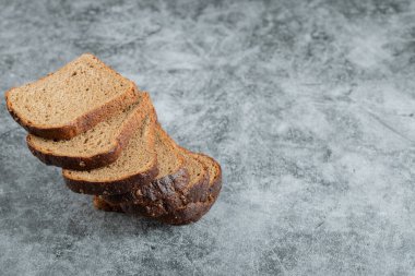 Gri arka planda kahverengi taze ekmek dilimleri