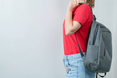 Öğrenci sırt çantasını omuzlarına takıyor.