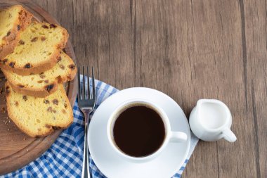 Tahtada bir bardak içkiyle servis edilen tatlı turta.