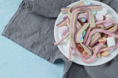 Beyaz tabakta renkli şekerlemeler ve jelibonlar