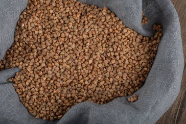 Gri kumaş içinde pişmemiş karabuğday yığını.