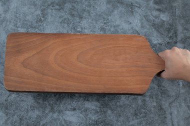 Elinde kare bir ahşap tabağı tutarken