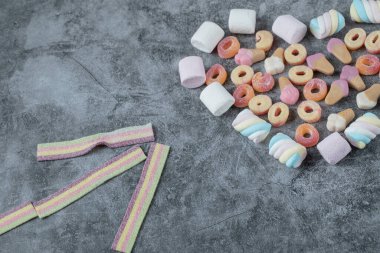 Mermer arka planda renkli şekerlemeler ve jelibonlar