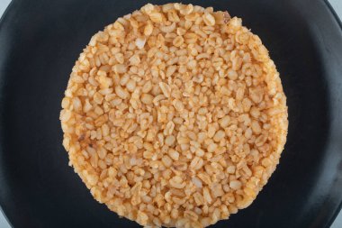 Beyaz zemin üzerinde koyu tabakta Türk yemek bulguru pirinci