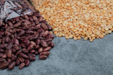 Gri arka planda hazırlıksız patlamış mısır ve kırmızı fasulye.