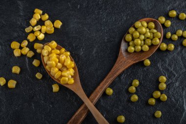 Konserve mısır tohumları ve yeşil zeytinlerin yakın fotoğrafını çek.