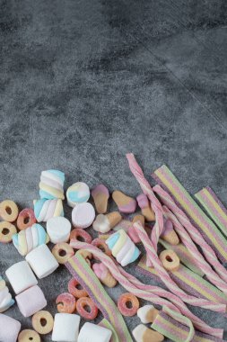 Mermer arka planda renkli şekerlemeler ve jelibonlar