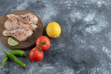 Çiğ organik tavuk bacağı ve yemek malzemeleri.