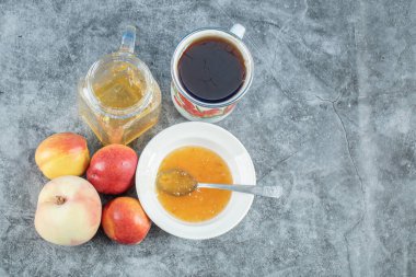 Meyveli şeftali reçeli ve bir fincan lezzetli çay.