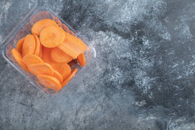 Havuç dilimleriyle dolu plastik kabın üst görüntüsü