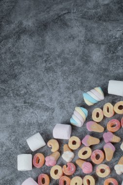 Mermer zeminde karışık şekerlemeler ve jelibonlar.