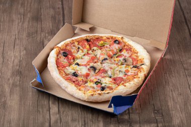 Pizza kutusundaki taze ve lezzetli pizzanın en üst görüntüsü.