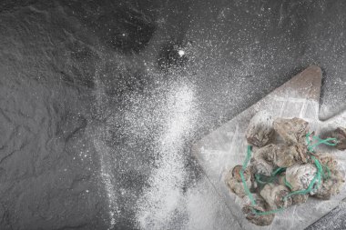 Siyah yüzeyde un ile süslenmiş kurumuş hurma ağaçları.