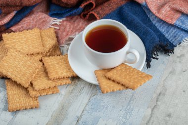 Tahta bir masada kraker ve bir fincan aroma çayı.