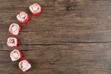 Tahta yüzeye yerleştirilmiş lezzetli California suşi ruloları.