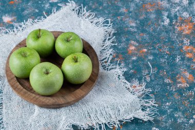 Yuvarlak ahşap tabakta sulu elmalar
