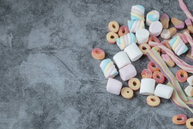 Marşmelov ve jelibon mermer arka planda izole edilmiş.