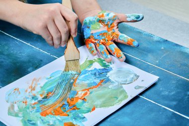 Ressam boya fırçasıyla beyaz kağıda resim çiziyor.