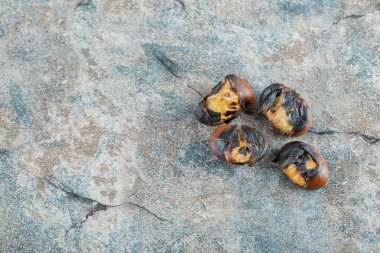 Gri arka planda lezzetli kızarmış kestaneler.