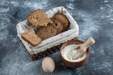 Gri bir arka planda sepetin üzerinde kahverengi ekmek dilimleri
