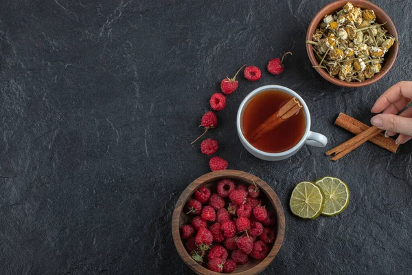 Siyah arka planda tarçın tutan kadın.