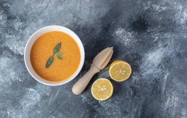 Limonlu beyaz bir kase mercimek çorbası.