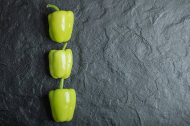 Koyu arkaplanda taze yeşil dolmalık biber.