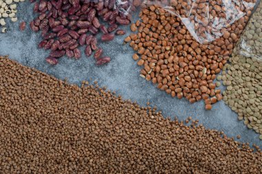 Mermer bir arka planda farklı türde çiğ fasulye.