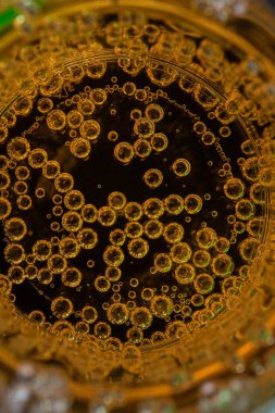 Siyah arkaplanda kabarcıklar olan sarı meyve suyu