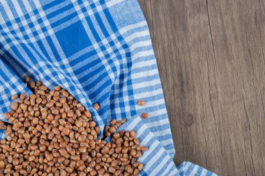 Masa örtüsünde çiğ kahverengi fasulye.